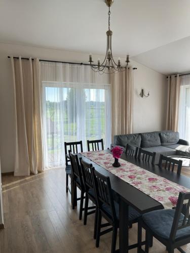 ein Esszimmer mit einem Tisch, Stühlen und einem Sofa in der Unterkunft Vila Trakai in Trakai