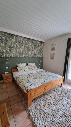 - une chambre avec un lit en bois et un tapis dans l'établissement Appartement Le Petit Vadrouilleur, à Ribeauvillé