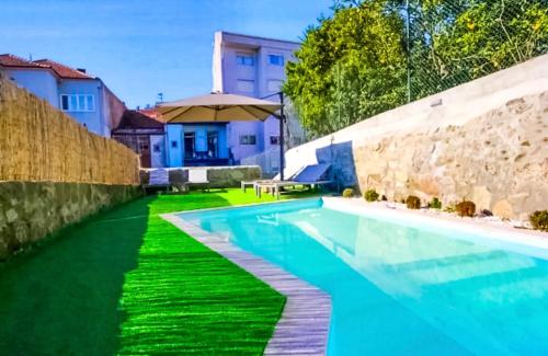 a swimming pool in a yard next to a stone wall at 1118 Lofts in Porto