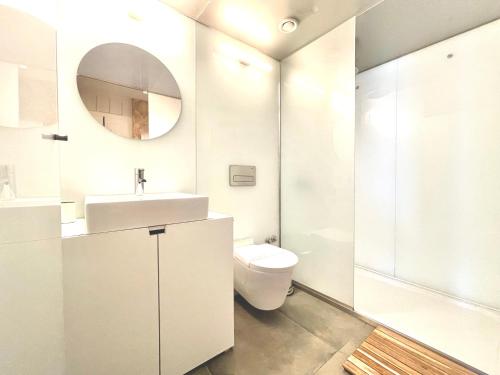 a white bathroom with a toilet and a sink at The Brewmaster's House in Porto