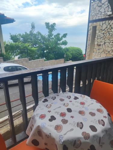 a table on a balcony with a view of the water at Jacky's Apartament - Апартамент в Свети Влас in Sveti Vlas