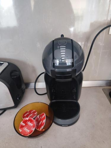 a black coffee maker with a bowl of red chocolates at Jacky's Apartament - Апартамент в Свети Влас in Sveti Vlas