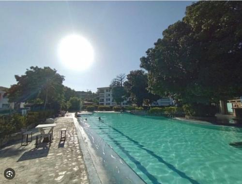 uma grande piscina com mesas e cadeiras em Chalet Condominio Campestre Rodadero Santa Marta wifi Piscina Amplia em Santa Marta