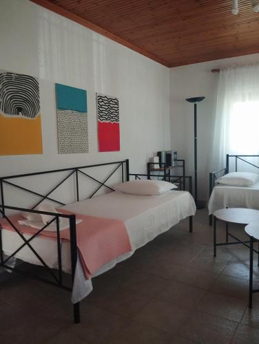 a bedroom with two beds and paintings on the wall at Raxoni House in Skala Rachoniou