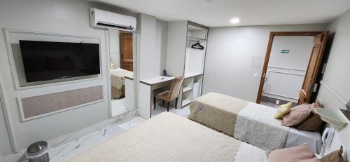 a small room with a bedroom with a tv on the wall at Antonio's Hotel e Spa - Airport in Brasilia