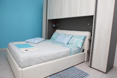 a small bed in a bedroom with blue walls at La Casa del Corso in Orgosolo