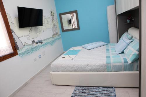 a bedroom with a bed and a tv on a wall at La Casa del Corso in Orgosolo