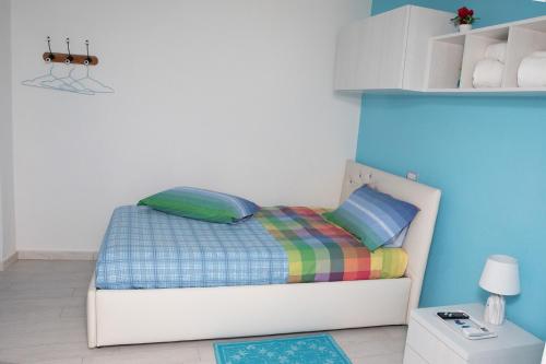 a small bedroom with a bed with a colorful blanket at La Casa del Corso in Orgosolo