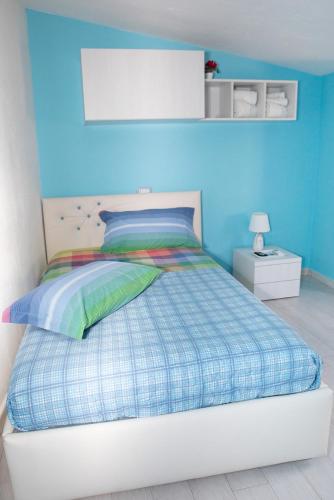 a bedroom with a bed with a blue wall at La Casa del Corso in Orgosolo