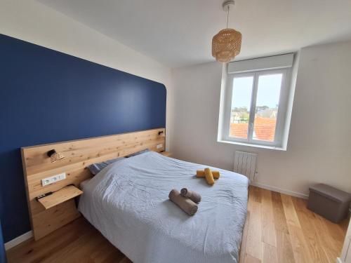 une chambre avec un lit avec deux ours en peluche dessus dans l'établissement Appartement au cœur de la Côte de Granit Rose., à Trégastel