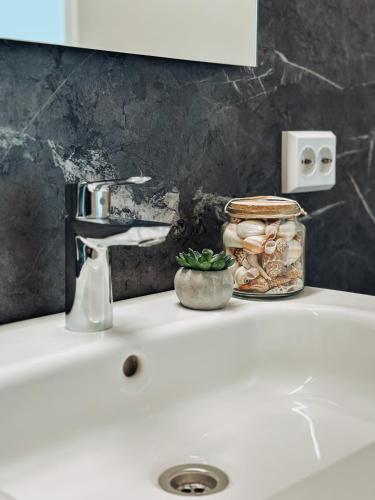 a bathroom sink with a jar of mushrooms on it at Preikestolen Panorama - Seaside Apartments in Strand