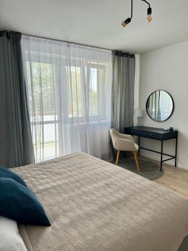 a bedroom with a bed and a desk and a mirror at Apartment ZANzi in Šamorín