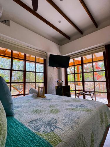 a bedroom with a large bed with a flat screen tv at Miraflores Boutique Hotel Adults Only in San Andrés