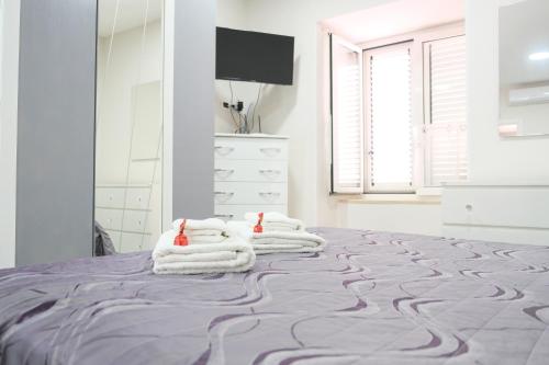 a bedroom with a bed with towels on it at Casa Davide in Torre Annunziata