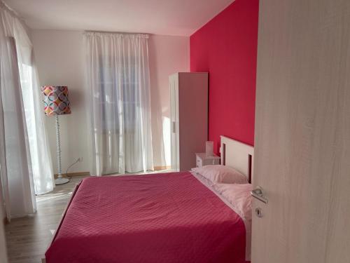 a pink bedroom with a bed with a pink blanket at Villa Vittoria in Stresa