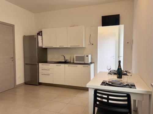 a kitchen with white cabinets and a table with wine glasses at Valpolicella Veneto1 in Negrar