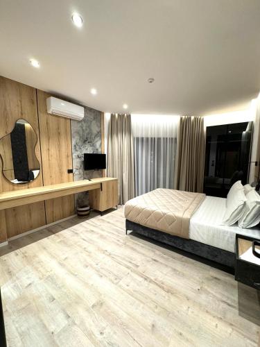 a bedroom with a bed and a desk and a television at Hotel Joni Premium in Ksamil
