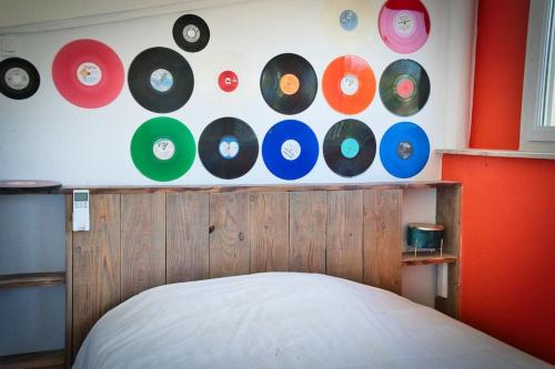 une pièce avec un tas de disques sur le mur dans l'établissement Maison atypique avec piscine 