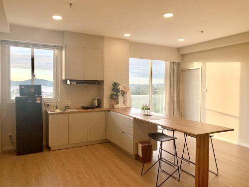 a kitchen with a table and a refrigerator and a counter at Deco Home @ Aru Suites in Kota Kinabalu