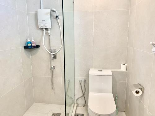 a bathroom with a shower with a toilet and a glass door at Deco Home @ Aru Suites in Kota Kinabalu