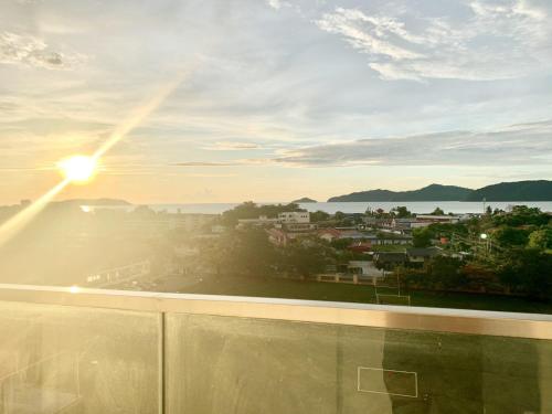a view of a city from a balcony with the sunset at Deco Home @ Aru Suites in Kota Kinabalu