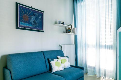 a blue couch in a living room with a window at Palazzo Vaaz in Mola di Bari