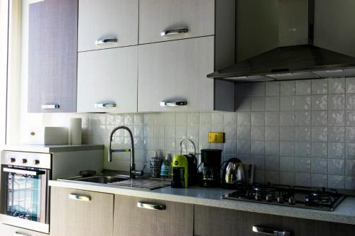 a kitchen with white cabinets and a sink and a stove at Palazzo Vaaz in Mola di Bari