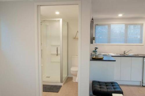 a bathroom with a shower and a toilet and a sink at Self contained studio apartment close to Mission Estate in Napier