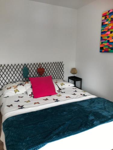 - une chambre avec un lit et un oreiller rose dans l'établissement Appartement neuf sur la Riviera bretonne, à Fouesnant