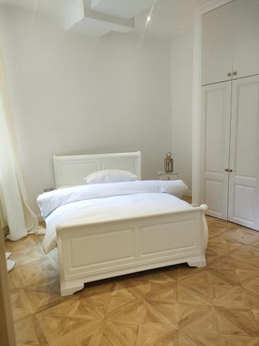 諾丁漢的住宿－Versailles，白色卧室铺有木地板,配有白色的床。