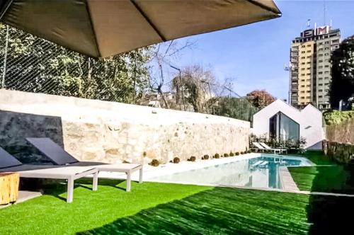 a backyard with a green lawn and a swimming pool at 1118 Lofts in Porto