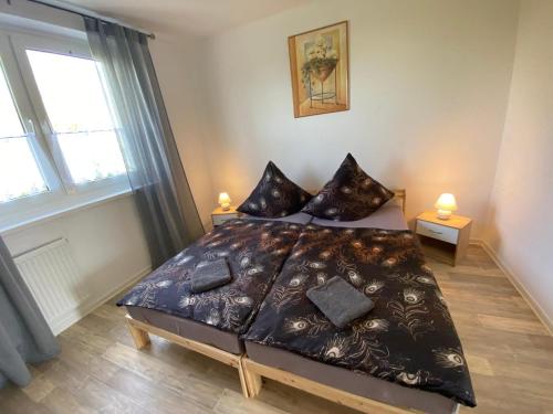 a bedroom with a bed and two lamps and a window at Neue Ferien Monteurwohnung mit 3 Schlafzimmer 22 in Wefensleben