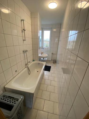 a white bathroom with a tub and a shower at Neue Ferien Monteurwohnung mit 3 Schlafzimmer 22 in Wefensleben