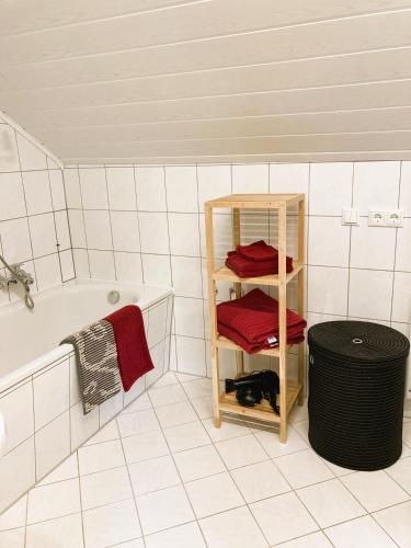 a bathroom with a shelf and a bath tub at Ferienwohnung Schickolores in Eibenstock