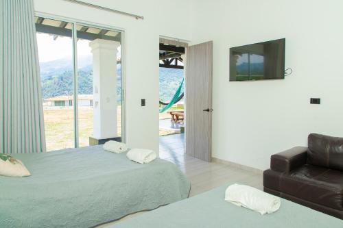 ein Schlafzimmer mit 2 Betten, einem Sofa und einem TV in der Unterkunft Casa del Lago in Copacabana