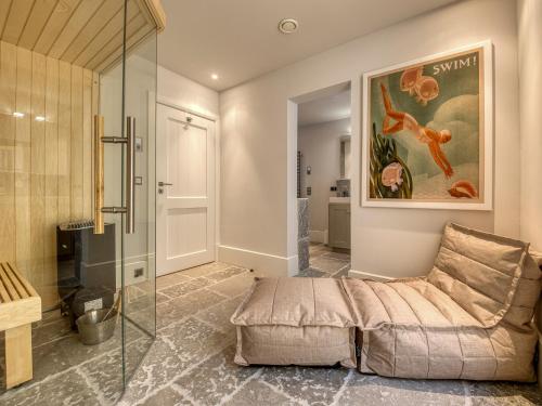 Un baño principal con cabina de ducha de cristal y una cama. en Haus Riva, en Wenningstedt