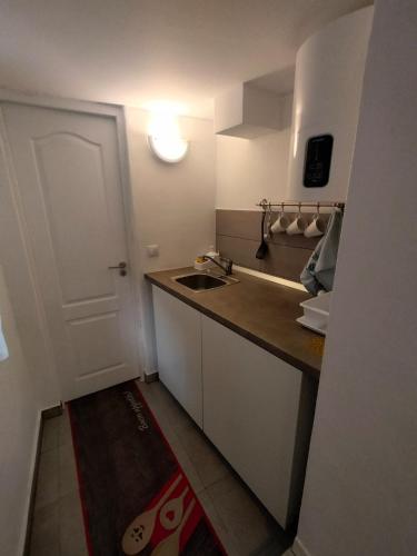 a small kitchen with a sink and a door at Studio Happy May in Sibiu