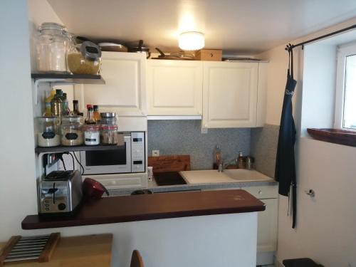une petite cuisine avec des armoires blanches et un évier dans l'établissement T3 centre et plage, à Saint-Brévin-les-Pins