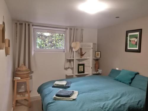 une chambre avec un lit bleu et une fenêtre dans l'établissement T3 centre et plage, à Saint-Brévin-les-Pins