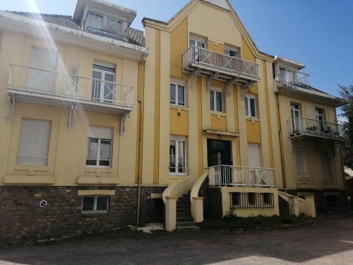 un bâtiment jaune avec des balcons sur son côté dans l'établissement T3 centre et plage, à Saint-Brévin-les-Pins