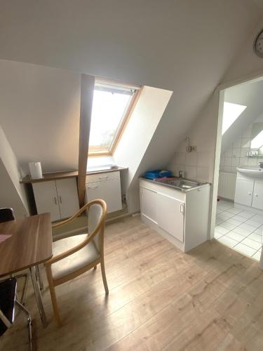 an attic kitchen with a table and a window at An de Bäk Bornstübchen in Born