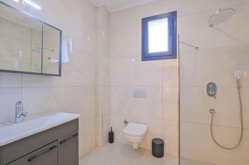 a bathroom with a shower and a toilet and a sink at Alternatif Villaları in Fethiye
