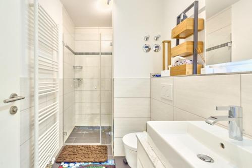 uma casa de banho com um chuveiro, um WC e um lavatório. em SeeVilla Scharbeutz em Scharbeutz