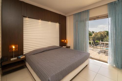 a bedroom with a bed and a large window at Tsokas Hotel in Finikounta