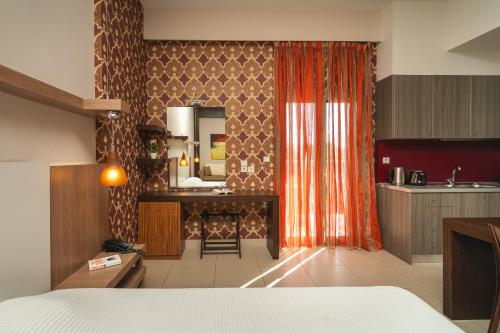 a room with a kitchen with a bed and a mirror at Tsokas Hotel in Finikounta
