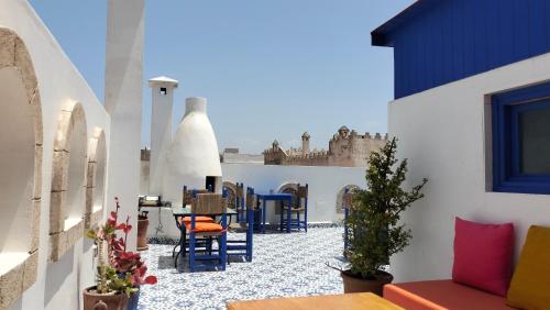 un patio con sillas y mesas en un edificio en Riad Al Manara, en Essaouira