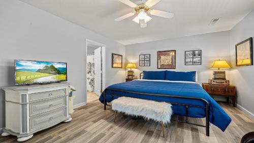 a bedroom with a blue bed and a flat screen tv at River Waltz in Pigeon Forge