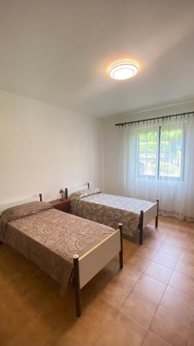 グラヴェドーナにあるCasa Blue lakeのベッド2台と窓のある寝室