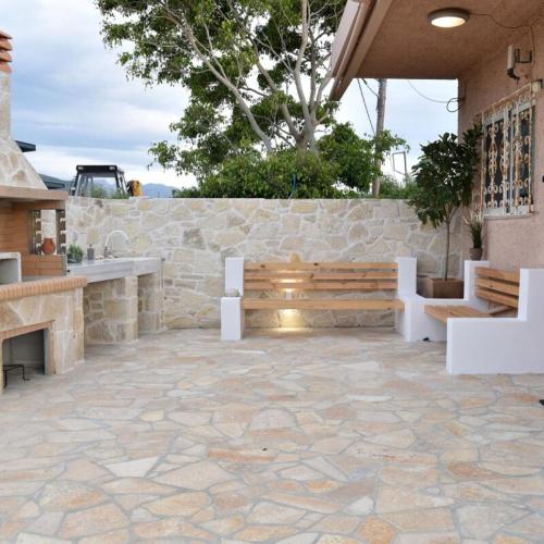 um pátio com um banco e uma parede de pedra em House near Balos in Kissamos em Kissamos