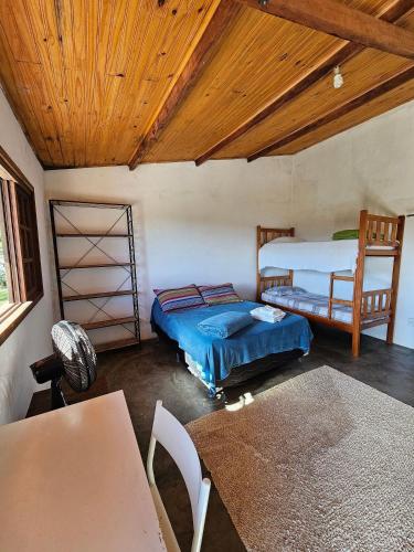 - une chambre avec deux lits et un plafond en bois dans l'établissement Sítio Mata Virgem, à Carrancas